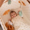 Baby in zijn bedje die naar de muziek van de mobile luistert Baby in zijn bedje die naar de muziek van de mobile luistert