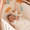Bebé no seu saco de dormir a brincar no berço