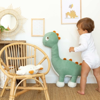 Bebé ao lado da sua grande peluche de diplodoco