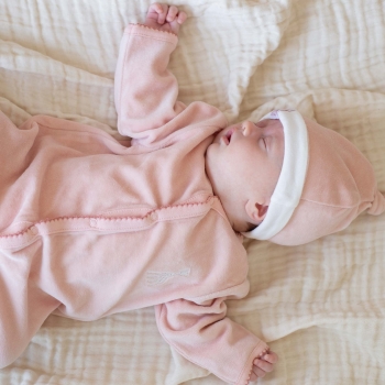 Baby sleeping with pink pajamas and pink Sophie the Giraffe bonnet