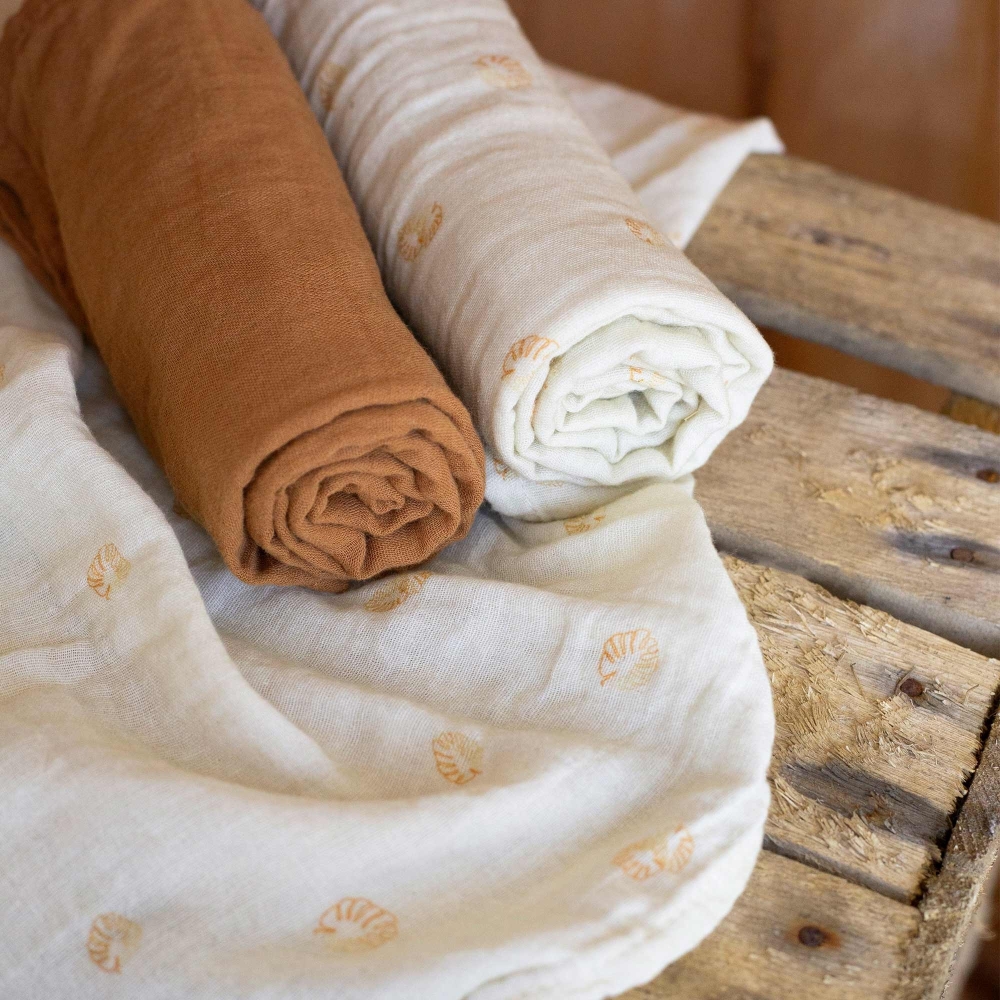 Baby swaddles on a wooden chest Baby swaddles on a wooden chest