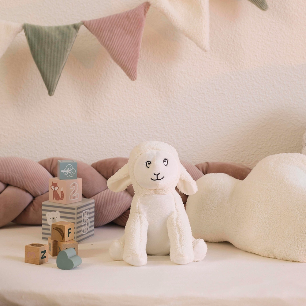 staged scene of a sheep plush toy in a baby play area staged scene of a sheep plush toy in a baby play area