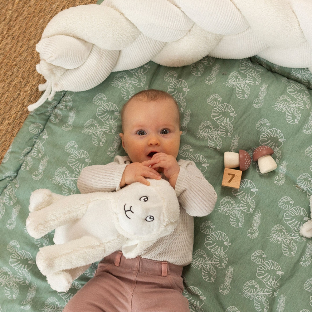 baby with its sheep stuffed animal on its play mat baby with its sheep stuffed animal on its play mat