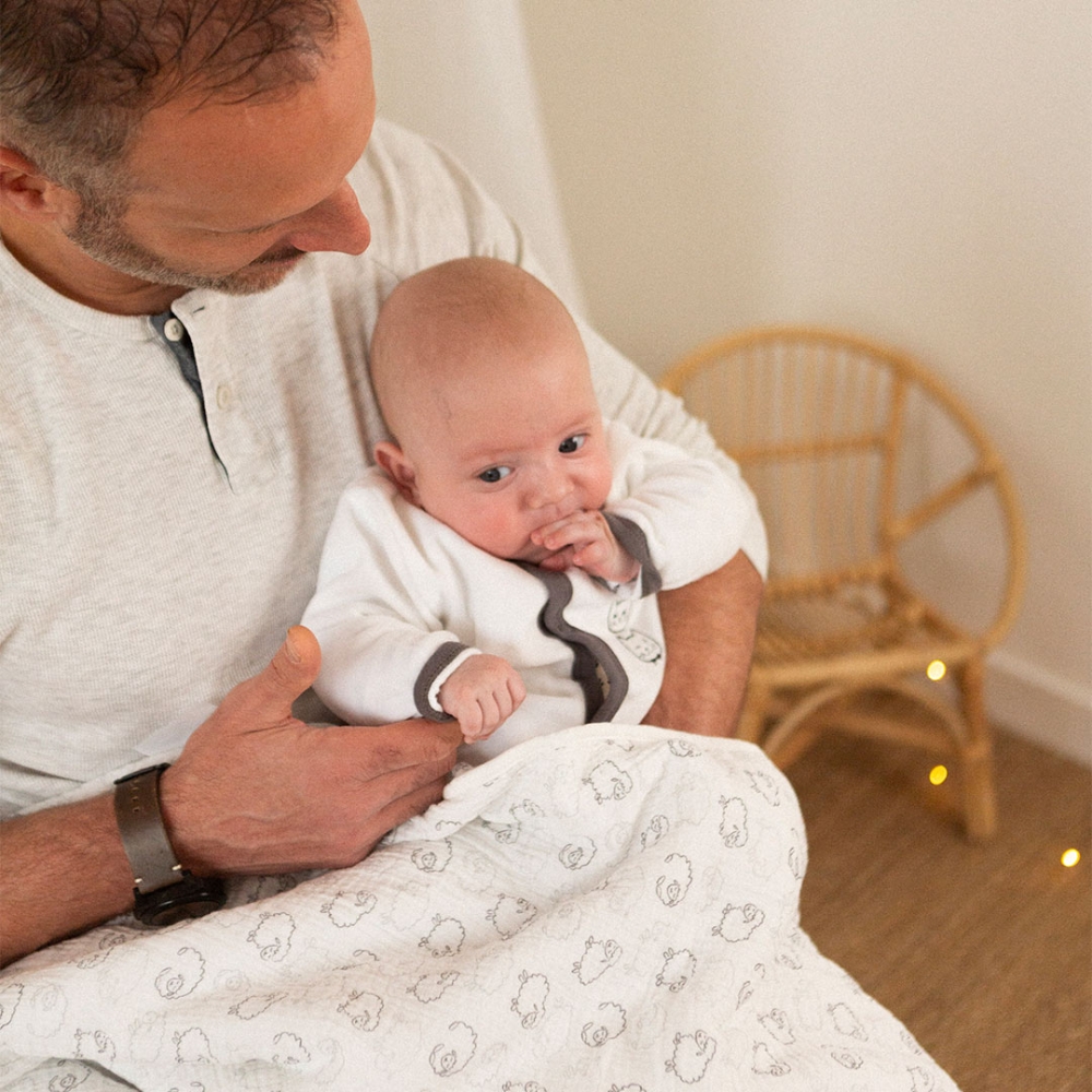 Bebè con il suo papà e la sua coperta pecora Bebè con il suo papà e la sua coperta pecora