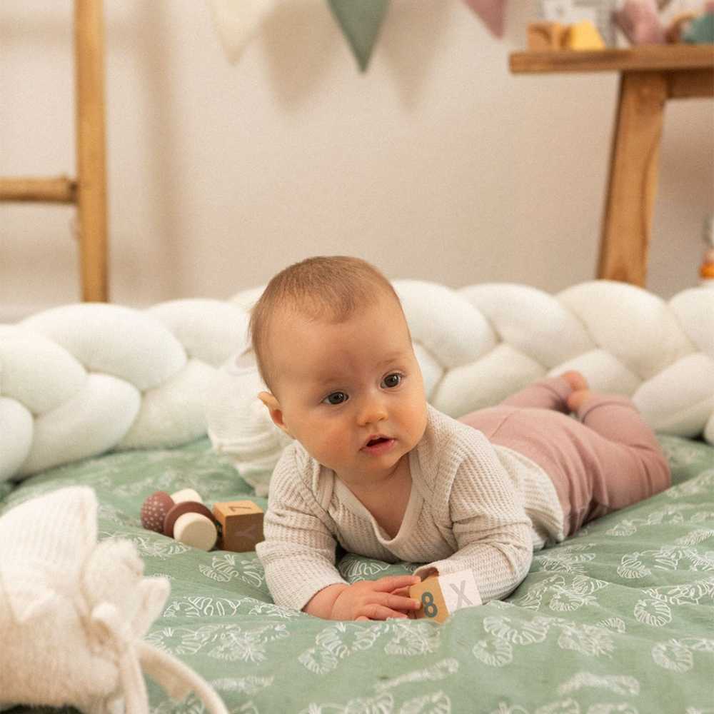 bebé no seu espaço de brincar com a sua trança de berço