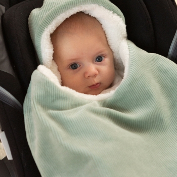 Baby in zijn autostoeltje met zijn voetenzak Baby in zijn autostoeltje met zijn voetenzak
