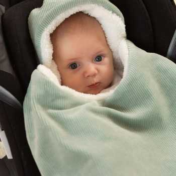 Bebé no seu assento de carro com o seu ninho de anjo