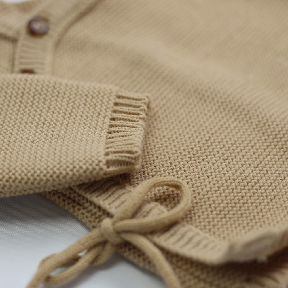 zoom sul tessuto del cardigan neonato color caramello zoom sul tessuto del cardigan neonato color caramello