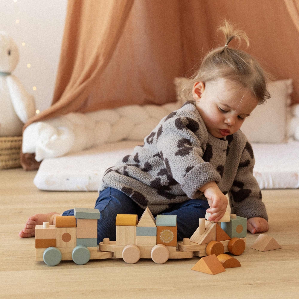 petite fille qui joue avec son train en bois petite fille qui joue avec son train en bois