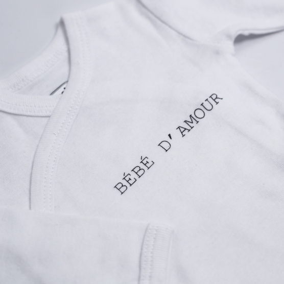 White baby bodysuit with "love baby" inscription