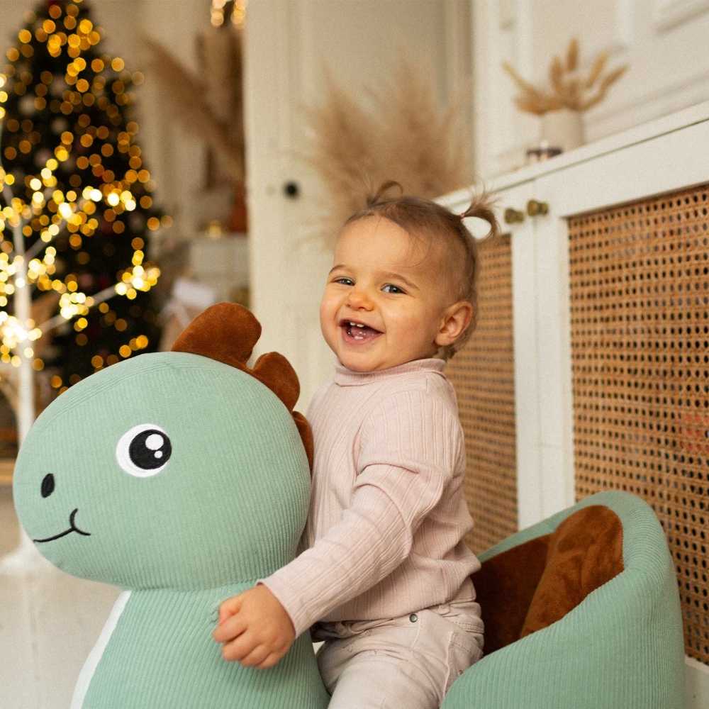 bebé na sua baloiça dino ao pé da árvore de Natal