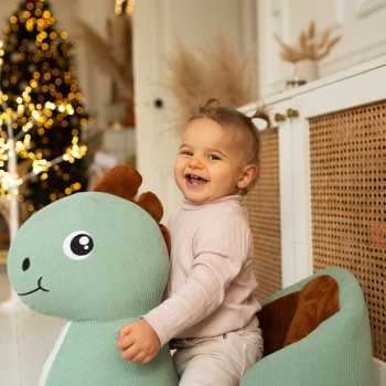 bebé na sua baloiça dino ao pé da árvore de Natal