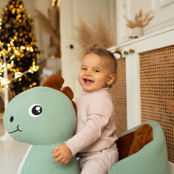 bébé sur sa bascule dino au pied du sapin bébé sur sa bascule dino au pied du sapin