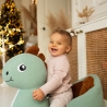 bebé en su balancín dino al pie del árbol de Navidad