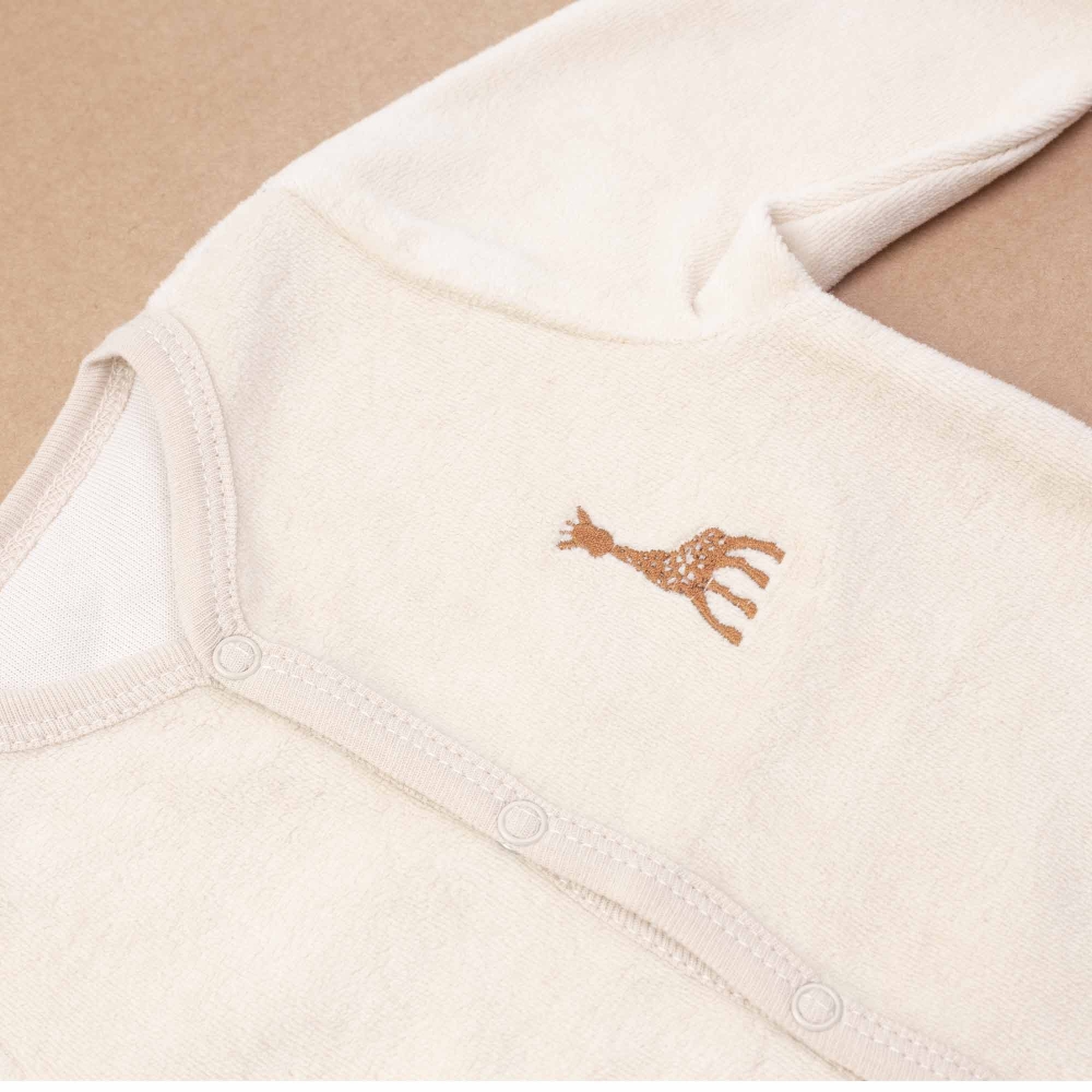 detail babypyjama met geborduurd embleem