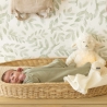 Bebé a usar o pijama num moisés com um projetor de sons brancos Wooly