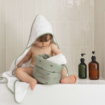baby after bath with hooded towel and toiletry basket