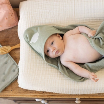 baby op aankleedkussen met zijn badcape baby