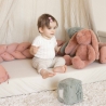 Sitzendes Baby mit seiner dekorativen Flechtschnur zum Gestalten seines Spielbereichs