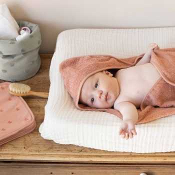 Fotografia de ambiente de um bebé no quarto com uma capa para o boletim de saúde do bebé