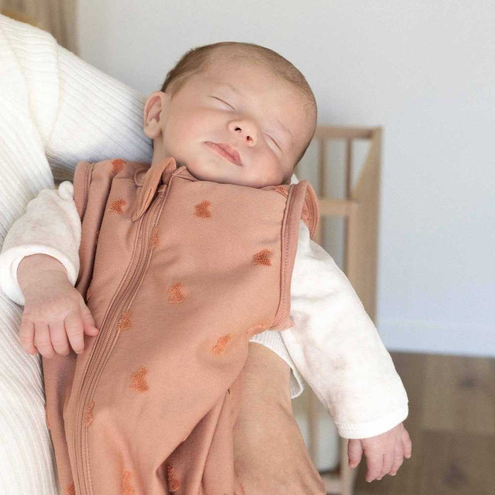 bebé ao colo da sua mamã com o seu saco de dormir