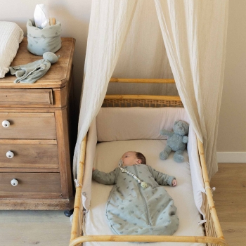 baby room with sleeping baby and clay green sleeping bag