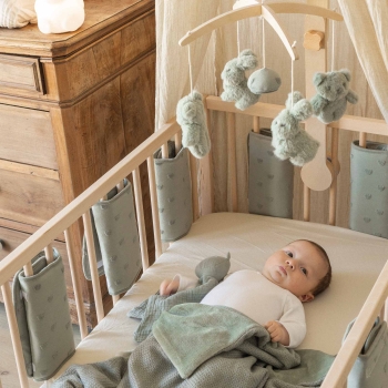 baby in bed with crib bumpers