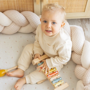 Baby spielt mit seinem Dekozopf hinter sich