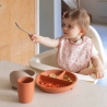 bebé a comer com o seu babete cor-de-rosa bebé a comer com o seu babete cor-de-rosa