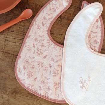 Pormenor dos motivos dos babetes para os primeiros meses em rosa e branco Pormenor dos motivos dos babetes para os primeiros meses em rosa e branco
