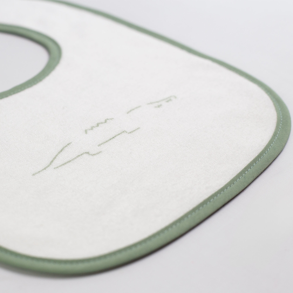 zoom materiaal van het beige babyslabbetje