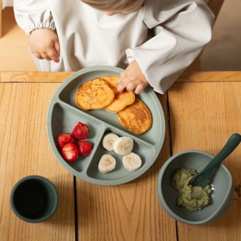 bebé con plato y cuchara de silicona
