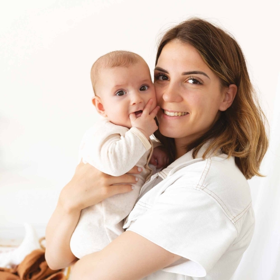 Fluwelen pyjama in ecru kleur die aan de voorkant opent met brandweerauto borduursel