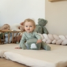 bebé a brincar com um cubo de atividades, vestido com um pijama de algodão verde-sálvia