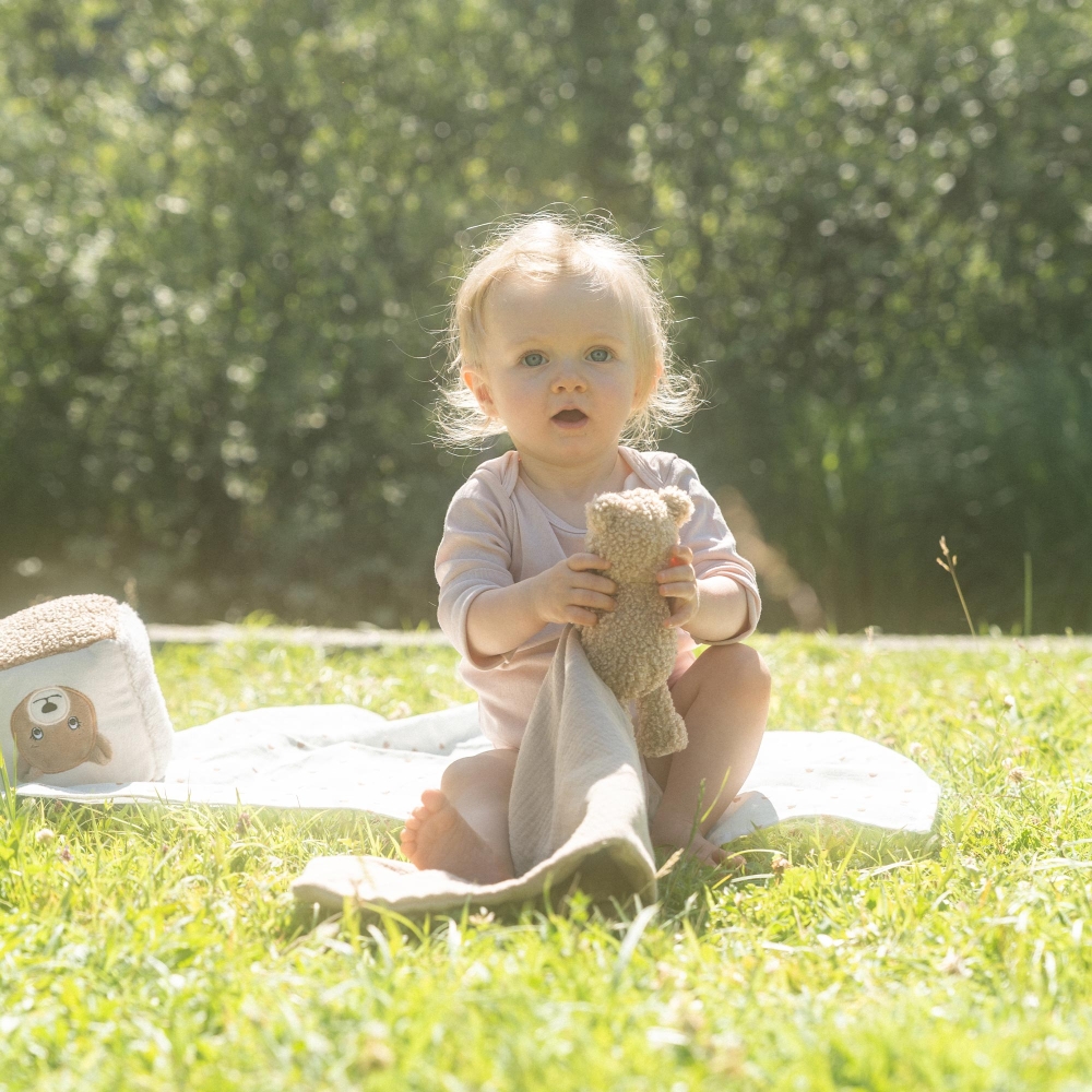 bébé avec son doudou mouchoir ourson