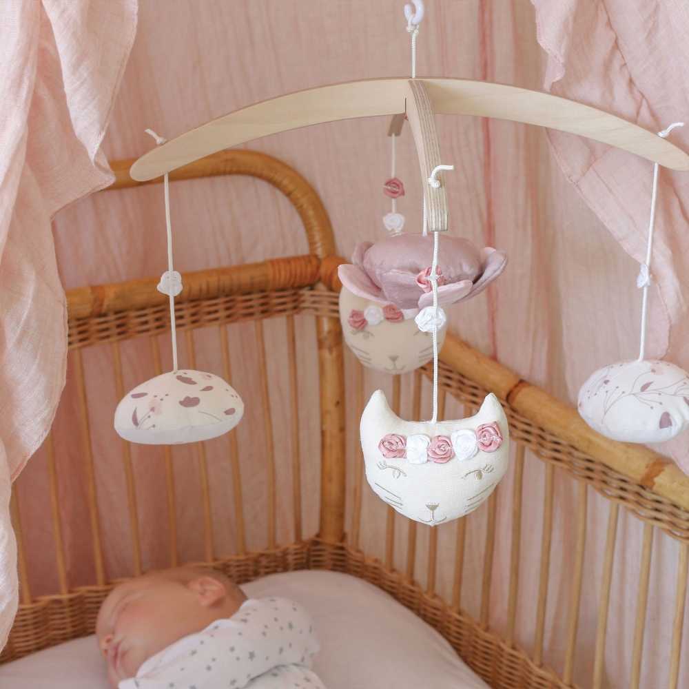 móbile musical acima de um bebé que dorme na sua caminha