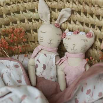 Boneca coelho com peluche rosa gato num cesto de vime