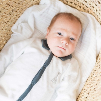 Baby in seinem weißen und blauen Pyjama mit Polokragen