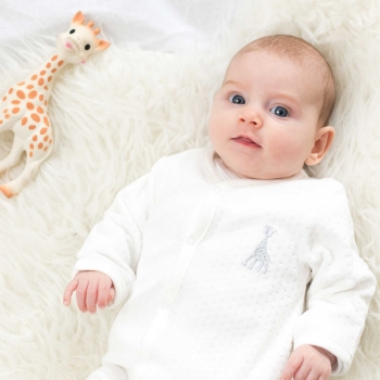 Baby im Samt-Pyjama und seiner Sophie die Giraffe