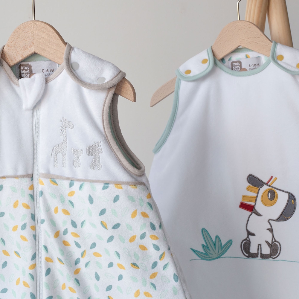 Two baby sleeping bags hanging on wooden hangers from the Kolala and tribe collection Two baby sleeping bags hanging on wooden hangers from the Kolala and tribe collection