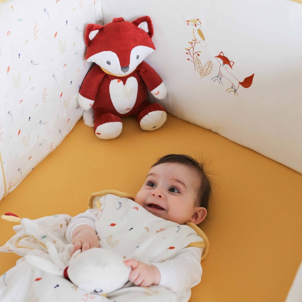 Bébé trop content dans son lit décoré du thème de la forêt avec le tour de lit, la gigoteuse assortie et son doudou renard Bébé trop content dans son lit décoré du thème de la forêt avec le tour de lit, la gigoteuse assortie et son doudou renard