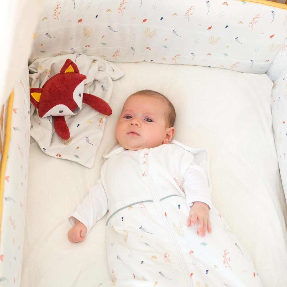 Bebé en su cuna en saco de dormir con su doudou zorro