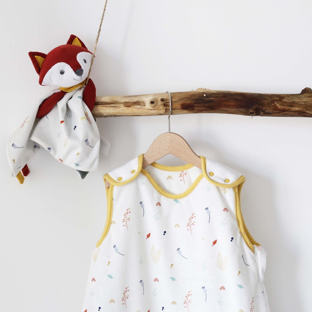 Baby sleeping bag hanging on a wooden wardrobe with Leonard the comforter Baby sleeping bag hanging on a wooden wardrobe with Leonard the comforter