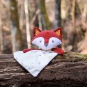 Fox plush toy staged on a tree trunk