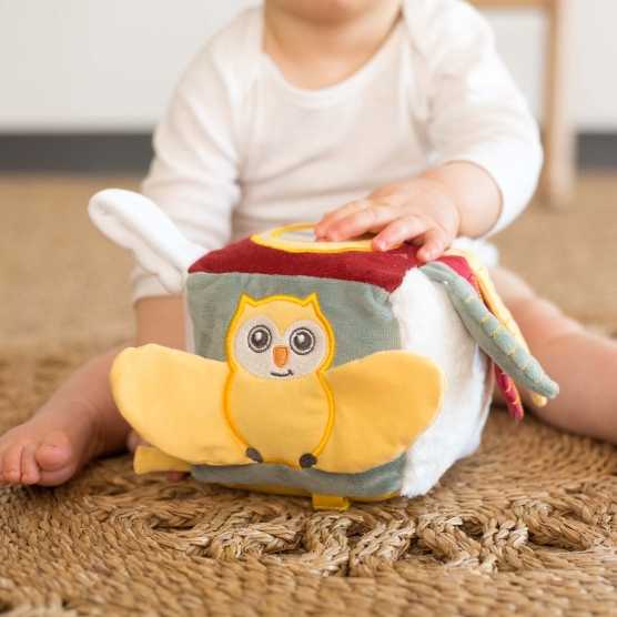 Cubo de atividades com uma pequena coruja em relevo e um pequeno espelho na parte superior
