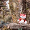Musikspielzeug Eule versteckt hinter dem Baum, um den Fuchs zu beobachten