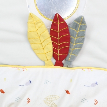 Trois feuilles moutarde, terracotta et sauge accroché sur le sol du tapis d'éveil