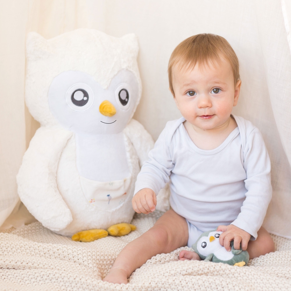 Peluche Violette junto al bebé en el espacio de juego