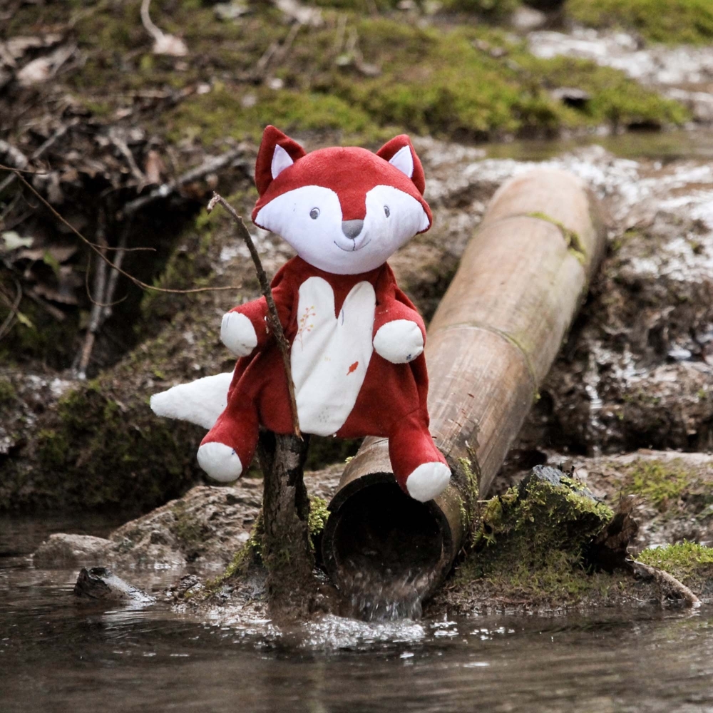 Leonard the fox puppet staged by a river in the forest Leonard the fox puppet staged by a river in the forest