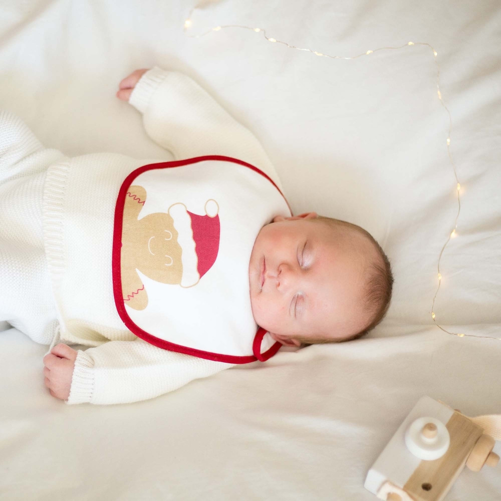 Schlafendes Baby mit Weihnachtslätzchen Schlafendes Baby mit Weihnachtslätzchen